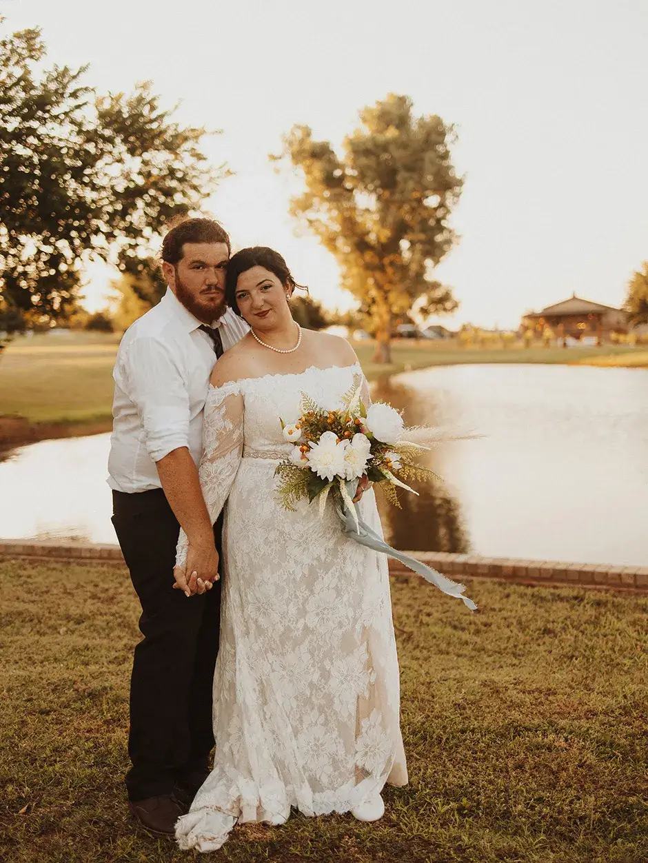 plan-your-big-day A bride and groom stand next to a pond