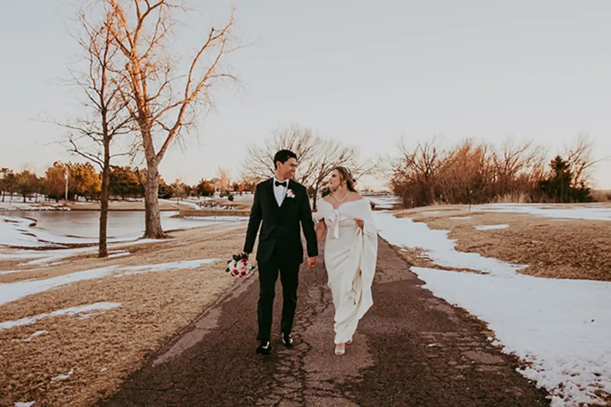 A bride and groom walking the snow-covered grounds at Clauren Ridge