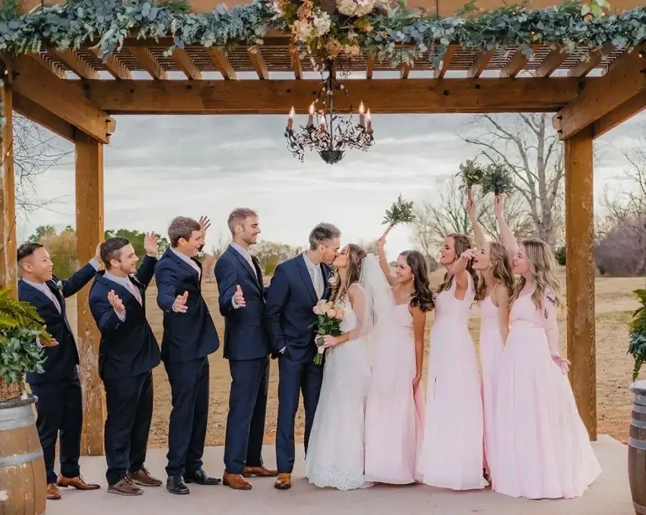 Sophistication in Every Detail Bride and groom with parties under pergola