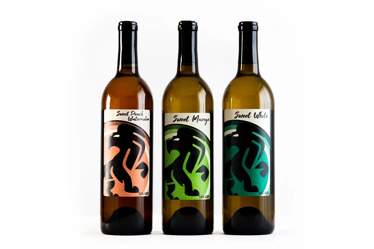 An eye-level shot shows three 750ml bottles of Suseet wine, each featuring a label with a stylized, tribal-style black lion silhouette.